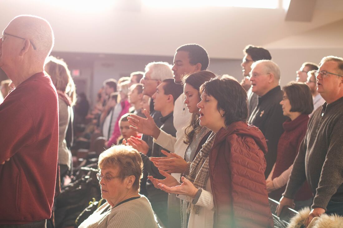 A congregation worships together in a sunny church.