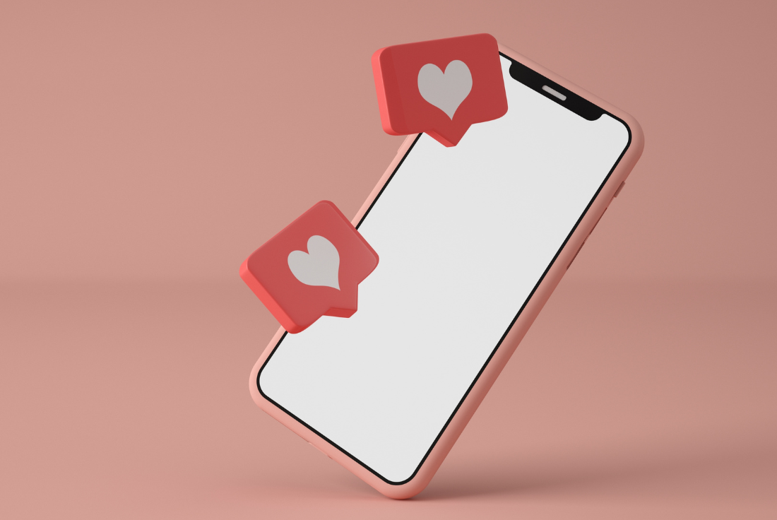 A phone hovers against a blank background. Two comment bubbles with hearts hover over the phone.